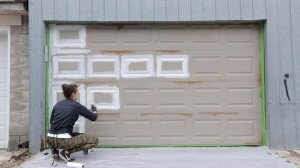 woman painting garage door panels first