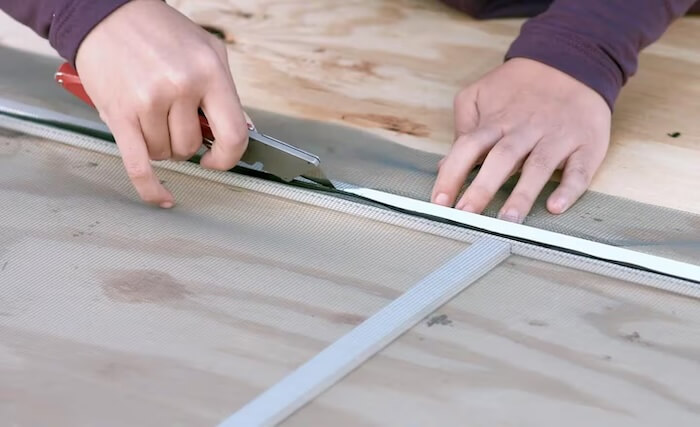 person repairing a window screen
